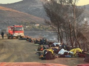 Εξαντλημένοι πυροσβέστες ξαπλώνουν στο χώμα για να ξεκουραστούν